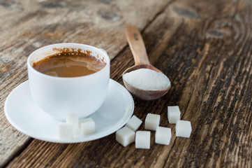 cup of coffee with milk and sugar spoon on the table