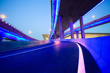 Empty road floor with city viaduct bridge of neon lights night