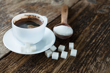 cup of coffee with milk and sugar spoon on the table