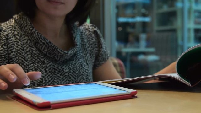Businesswoman in cafe working with documents and using tablet computer. Doing job outside the office