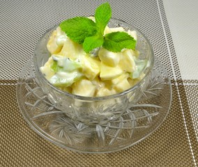 Dessert of exotic fruits - finely chopped banana, kiwi, apple, pear and orange, seasoned with low-fat yogurt