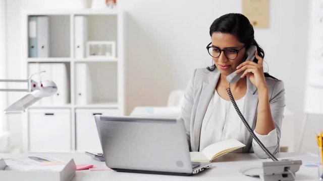 businesswoman with pad calling on phone at office