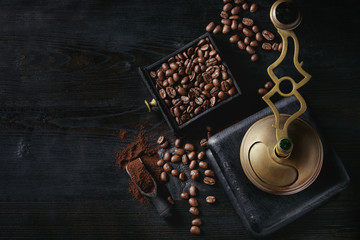 Roasted coffee beans and grind coffee in wood box with vintage coffee grinder and scoop over black...