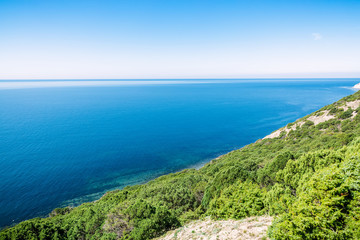 Fototapeta na wymiar Blue sea and cliff with juniper in the Mediterranean. Summer day on sea