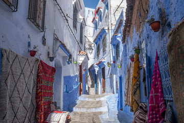 Fototapeta na wymiar Blue Alley with Carpets in the Medina of Chefchaouen