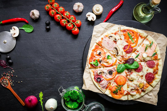 Food frame with italian pizza, ingredients, vegetables and spices on dark background. Flat lay, top view. Food background