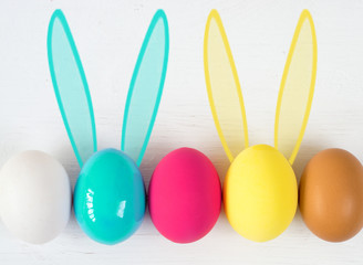 Easter eggs with Rabbit ears in colored buckets on white, selective focus image, Card Happy Easter 