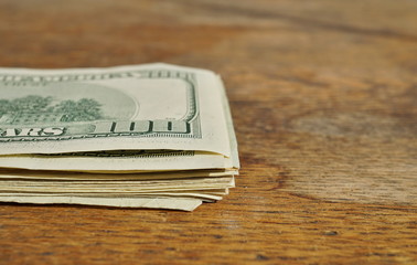 Heap of American money (US currency, USD) on the wooden background as a symbol of wealth 