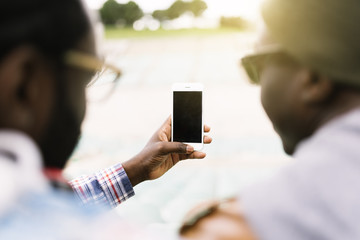 Two black race friends having fun with mobile.