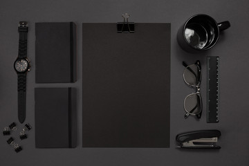 Black objects from the office on a dark gray background. Work and creativity. Top view.