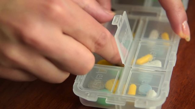 Close-up shot of woman taking some medicines from the pill box
