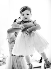 Black and white picture of little girl in mother's arms