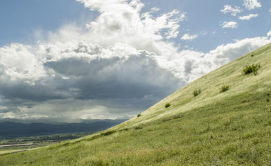 Green grass valley on cloudy day