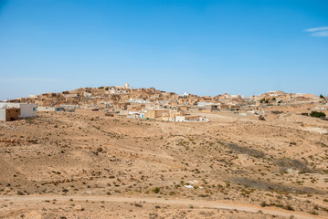 Traditional Arabian city on sand dunes in the desert
