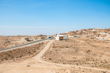 Highway in the desert passing through a small Arab town
