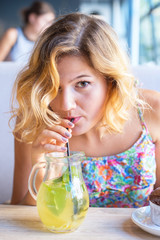 Portrait of beautiful young woman who is drinking cocktail in cafe