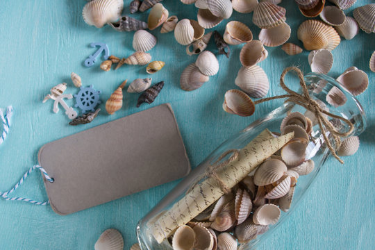 Summer background on wood with message in bottle and tag for text.Marine concept.