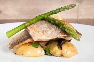gourmet seafood dish of fish and asparagus on a white plate