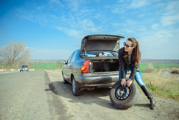 woman rolls car wheel