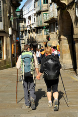 Couple of pilgrims on the streets of Santiago de Compostela, end of the way, Spain