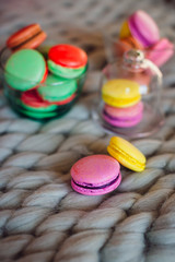 Yellow and violet macaroons lie on grey woolen plaid
