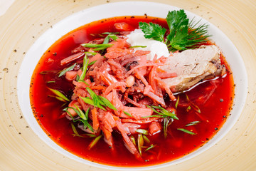 Ukrainian and Russian traditional beetroot soup - borscht in bowl with sour cream and herbs