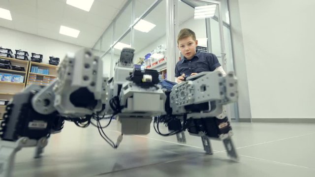 School student controls self-made robot at engineering school lab. 4K.