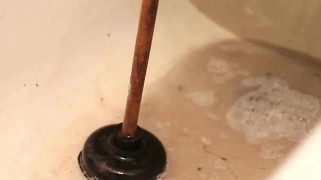 Clogged Drain Water in the Bathroom Near the black plunger