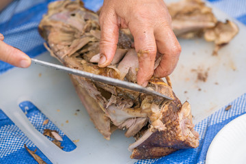 Chef slicing peking duck at the chinese restaurant. 
Cutting of Peking Roast Duck on cutting board.