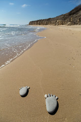 Footprint made of pebbles on the beach