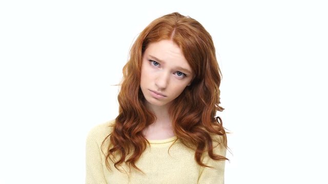 Sad disappointed young girl with long curly hair looking at camera isolate over white