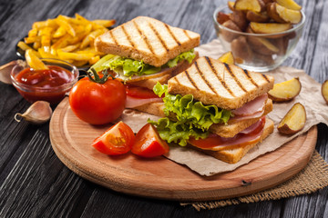 club sandwich with Tomato, lettuce, bacon, ham and french fries