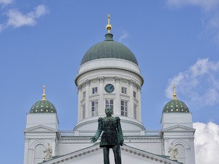 The dome of Helsinki Cathedral and statue of Emperor Alexander II under the blue sky, Helsinki,...