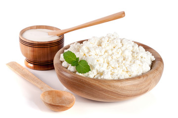 Fototapeta na wymiar Cottage cheese in a wooden bowl isolated on a white background