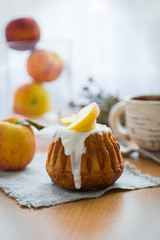 Rom-cakes with peaches and a cup of tea on a sackcloth on wooden background. Breakfast,morning. Top view. Close up. S