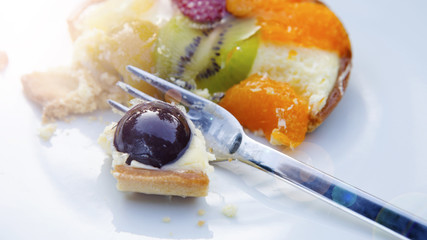 plate with round fruit tart and fork.