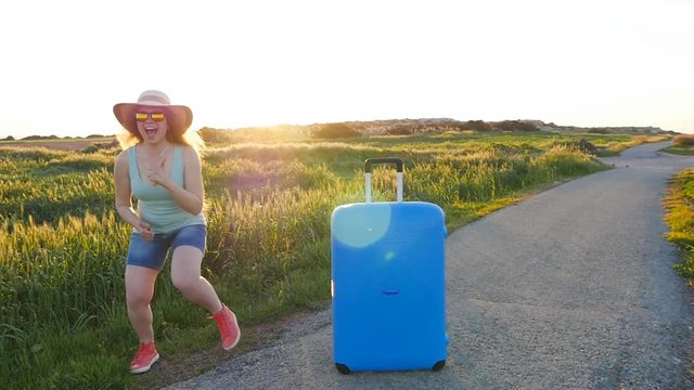 Hapy young woman with suitcase. Travel concept
