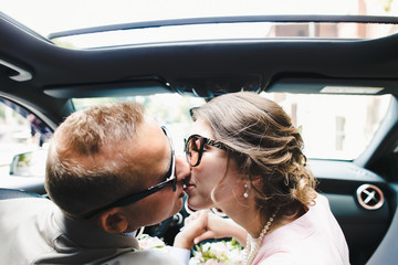 Man and woman kiss each other sitting on front seat in the Mercedes