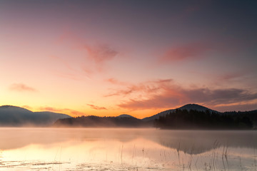 Red dawn by the misty lake