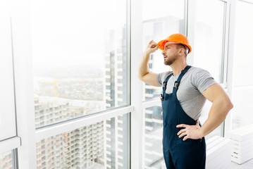 Professional construction engineer standing near window