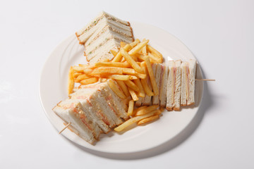 Different types of sandwiches with French fries on a white plate