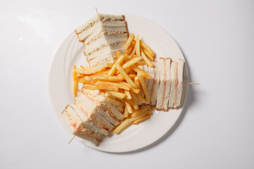 Different types of sandwiches with French fries on a white plate