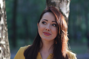Fototapeta premium Portrait of a beautiful woman on a forest background. People