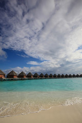Traditional Maldives bungalows on wooden pier in tropical paradise