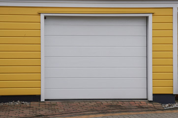 Gelbe Garage mit wei&szlig;em Tor
