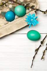 Easter background with eggs and catkins on white wooden background, copy space