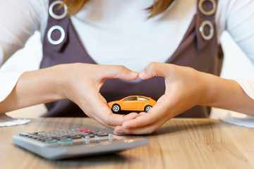 Hands of woman making hearth shape with car insurance concept.