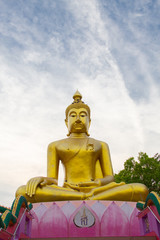 Big Golden Buddha statue over scenic white and blue sky  at Wat Sai Dong Yang Temple. Phichit, Thailand.