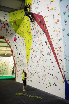 Man practicing rock climbing on artificial climbing wall 