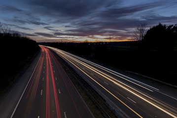 Fototapeta na wymiar A UK motorway, at sunset, with light trails created by the traffic on the road